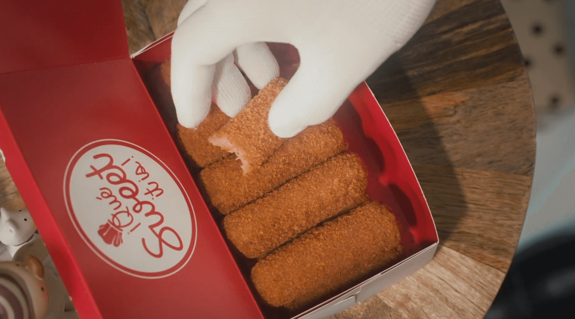 Close-up of Santa Claus hand in a white glove picking up a Vicky Bakery's croqueta