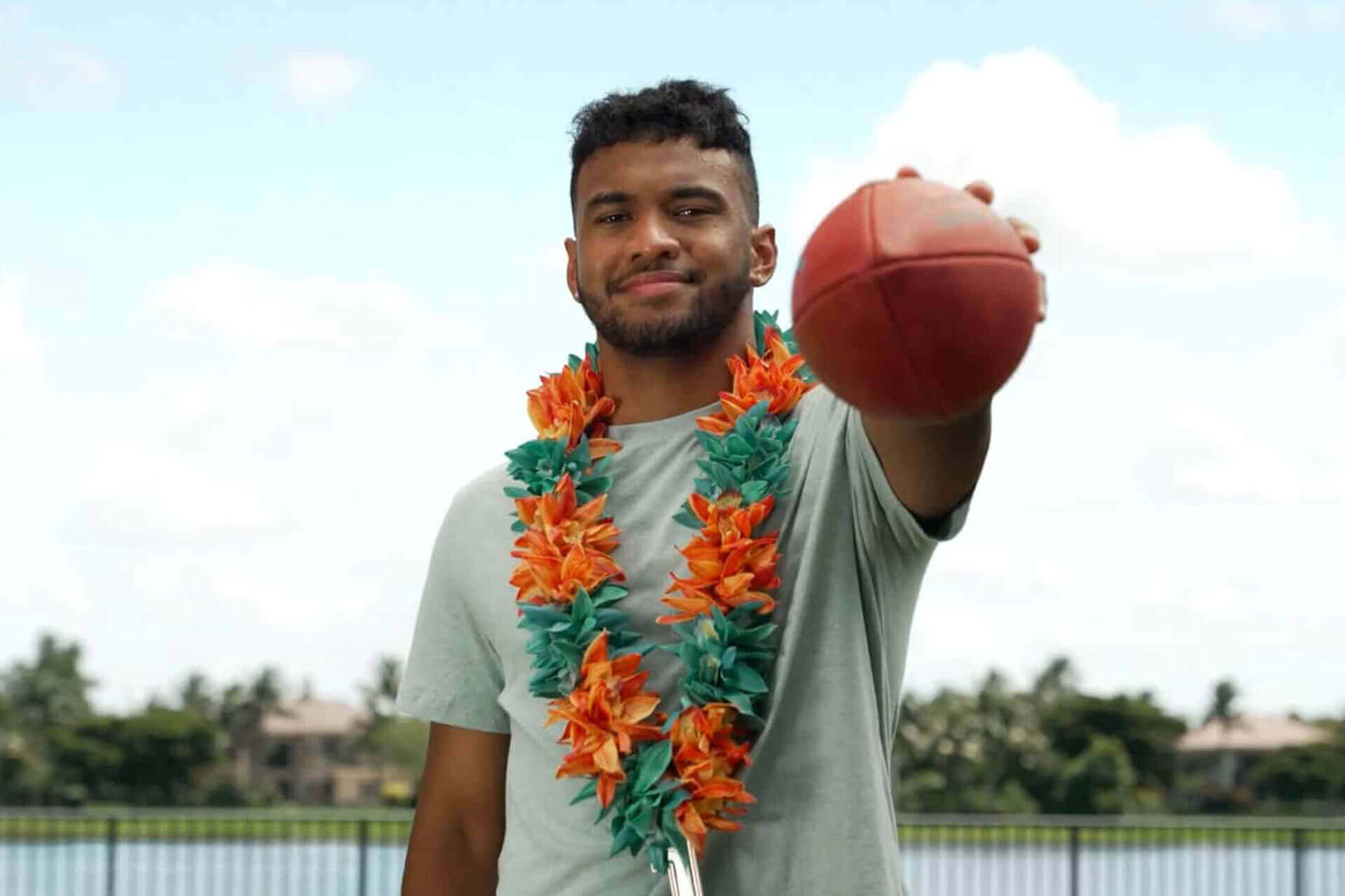 Tua Leis with a football for the campaign with South Florals